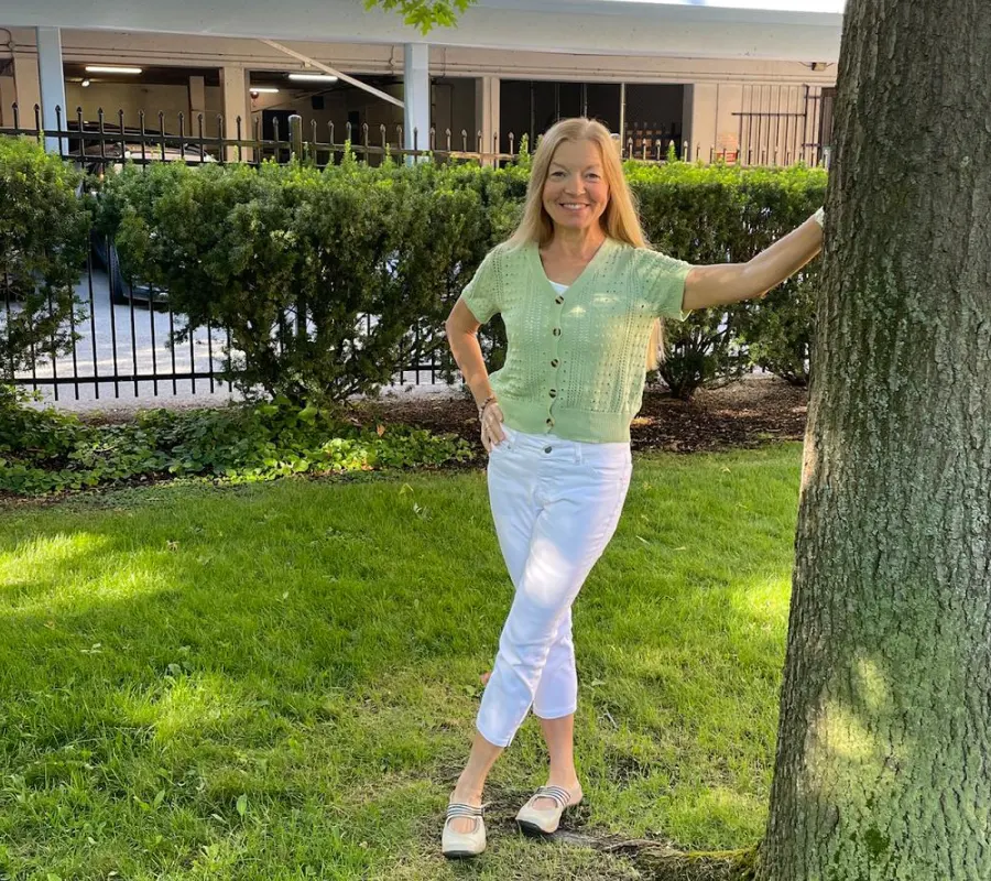 Linda outdoors beside a tree